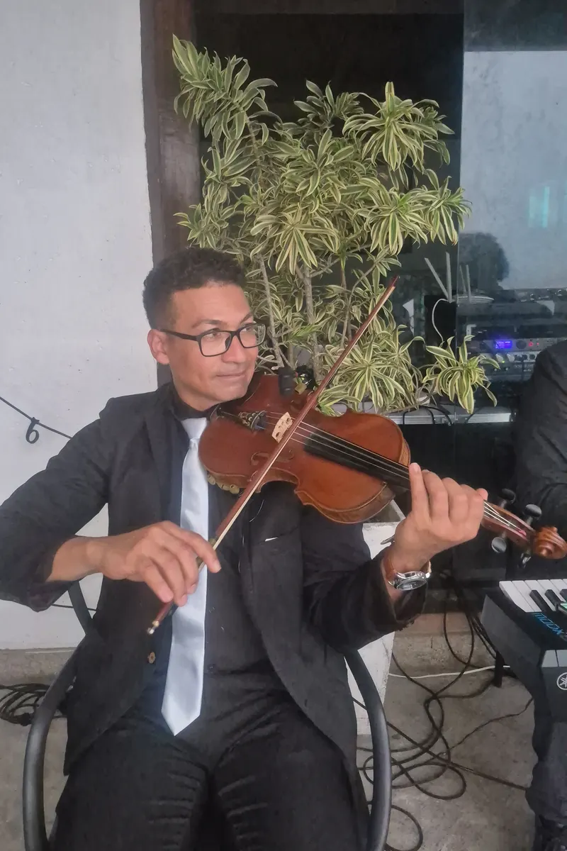 Violinista do Grupo Rio Cordas tocando ao lado do teclado